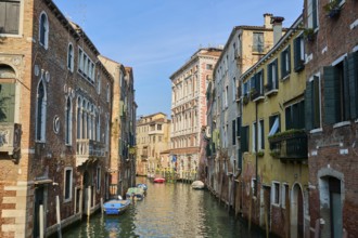 View on a waterway with boats lying in the water in Venice on a sunny day in winter, Italy, Europe
