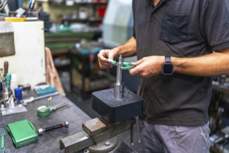 Close-up of unrecongizable man measuring metal pieces using a micrometer in a cnc factory