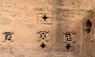 Cross-shaped windows carved in stone in the underground monolithic rock-hewn church of Biete