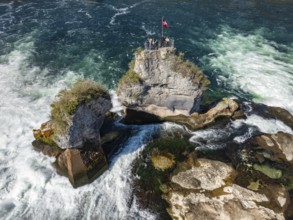 Aerial view of the Rhine Falls at low water in spring, with tourists on the viewing platform,