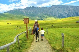 Tourists enjoying a scenic hike in the beautiful alpe di siusi, surrounded by the stunning mountain