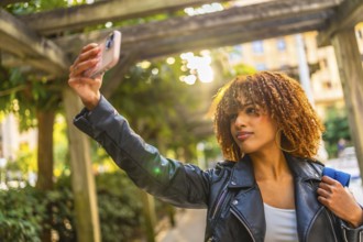 Latin beauty young woman taking selfie while enjoying a walk in the city