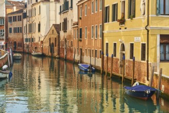 View from 'Casa di otello' over a waterway with boats lying in the water in Venice on a sunny day