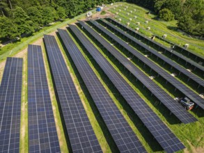 Long rows of solar panels on a green area from an aerial perspective, construction of the Black
