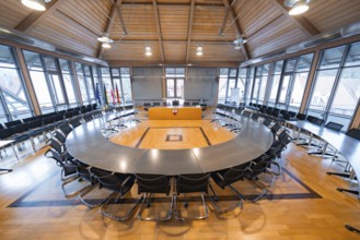 Large, modern conference room with wooden ceiling and large windows, equipped with table and