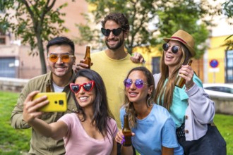 Multi ethnic group of friends partying in the city park taking a selfie, friendship and fun concept