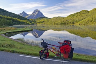 Packed touring bike in front of mountain lake and steep mountains, no cars, bicycle trip, FV !7,
