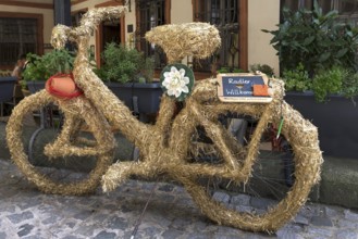Bicycle wrapped in straw, cyclists welcome, in front of a restaurant, Bamberg, Upper Franconia,