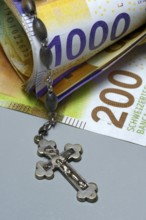 Crucifix and banknotes, Swiss francs, church and money