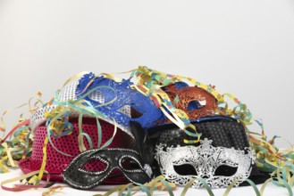 Various carnival masks and hats, surrounded by colourful streamers, carnival