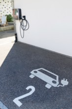 A parking lot with a charging station for electric cars. The parking lot has a white number 2 on