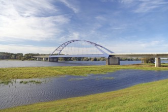 Modern bridge over a wide river on a sunny day with clear sky and some clouds, Bridge of Unity,