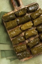 Dolma, minced meat with rice, in grape leaves, minced meat rolls, on a chopping board, top view, no