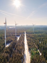 Wind turbines along a snow-covered road in a forest, Seewald, Black Forest, Germany, Europe