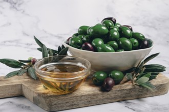 Chalkidiki olives, classic Greek green olives, in a bowl on a cutting board, top view, without