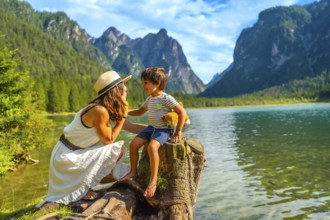 Mother and son sharing a tender moment while enjoying the breathtaking view of lake dobbiaco and