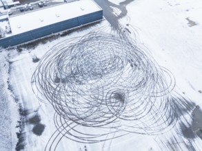 Tyre tracks form large circles on a snow-covered surface as seen from the air, Nagold, Black