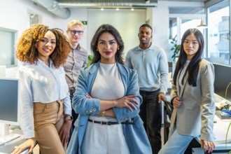 Multi ethnic team of professionals standing together in modern coworking office, showcasing