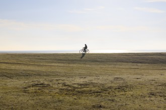 Cyclist on the south beach polder dyke, Norderney, Lower Saxony, Germany, Europe