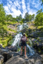 A female backpacker in summer at the Todtnau waterfall in the Black Forest in Germany