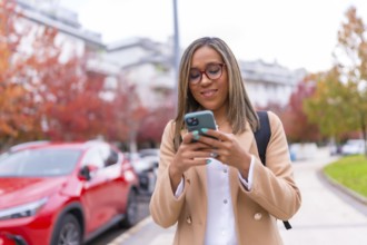 Latin beauty woman using phone sending message online walking in the city