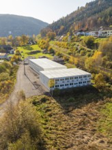 Industrial building on a hill with autumnal trees in a village, refugee accommodation Beermiß,