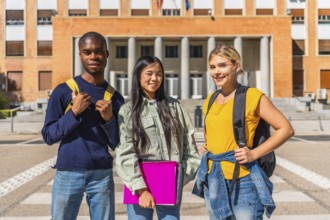 Portrait of three multi-ethnic students at the campus standing outside the entrance of the