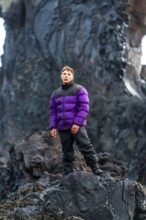 Portrait of an adventurous young man on Djupalonssandur beach in winter in Iceland