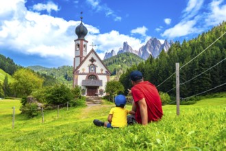 Father and son admiring the stunning view of the idyllic st. Magdalena church in the picturesque