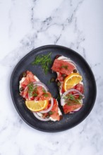 Sandwich with freshly smoked salmon, on black bread, with cottage cheese, with herbs and red
