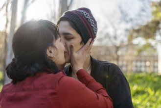 Young woman planting a sweet kiss on her girlfriend's lips