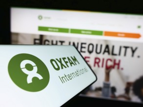 Stuttgart, Germany, 01-21-2023: Cellphone with logo of confederation Oxfam International on screen