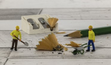 Little figures from little world cleaning up the mess of the mess of the pencil sharpener