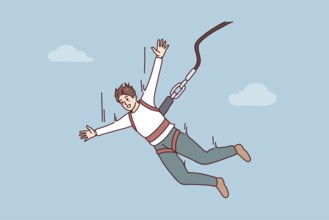 Excited young man jumping with parachute. Smiling guy enjoy extreme sport with rope jumping.