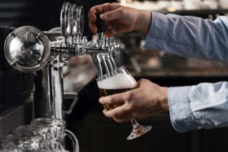 Close up hands pouring beer glass
