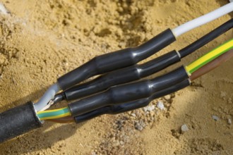 Connected power cables for house connection in the ground with heat-shrink tubing