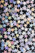 Colorful confetti stars on a dark background
