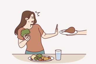 Vegetarian woman refuses meat and makes stop gesture in fear while eating fresh vegetables.