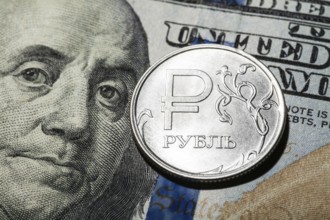 One ruble coin on dollar banknote. Closeup, macro shot