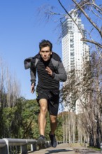Runner athlete silhouette running fast in public park