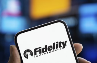 Fidelity investments logo is displayed on smartphone. Fidelity Management & Research is an American