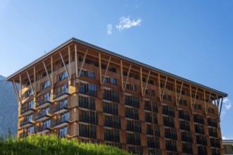 Beautiful Modern Hotel Building in Wood and with Mountain in a Sunny Summer Day in Andermatt, Uri,