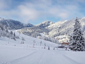 Picturesque snowy mountain landscape with slopes, lifts, and skiers at La Clusaz ski resort,