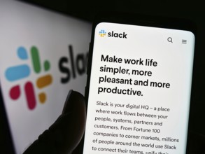 Stuttgart, Germany, 12-30-2022: Person holding cellphone with webpage of US software company Slack