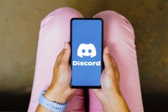 In this photo illustration, the Discord logo is displayed on a smartphone screen