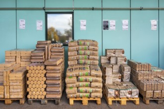 Plastic bags with wood pellets, wood briquettes and firewood at a wholesale market, Allgäu,