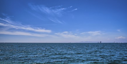 Panoramic beautiful seascape on a bright summer day with few sailing boats afar, great sky with