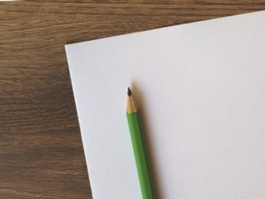 Green pencil on paper sheet desk