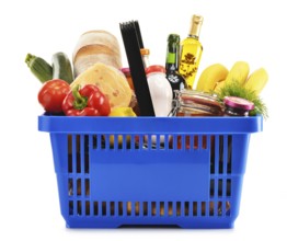 Plastic shopping basket with variety of grocery products isolated on white