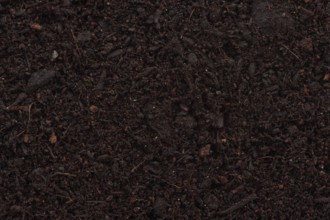 Organic potting soil mix enriched with compost abstract background texture closeup of particles